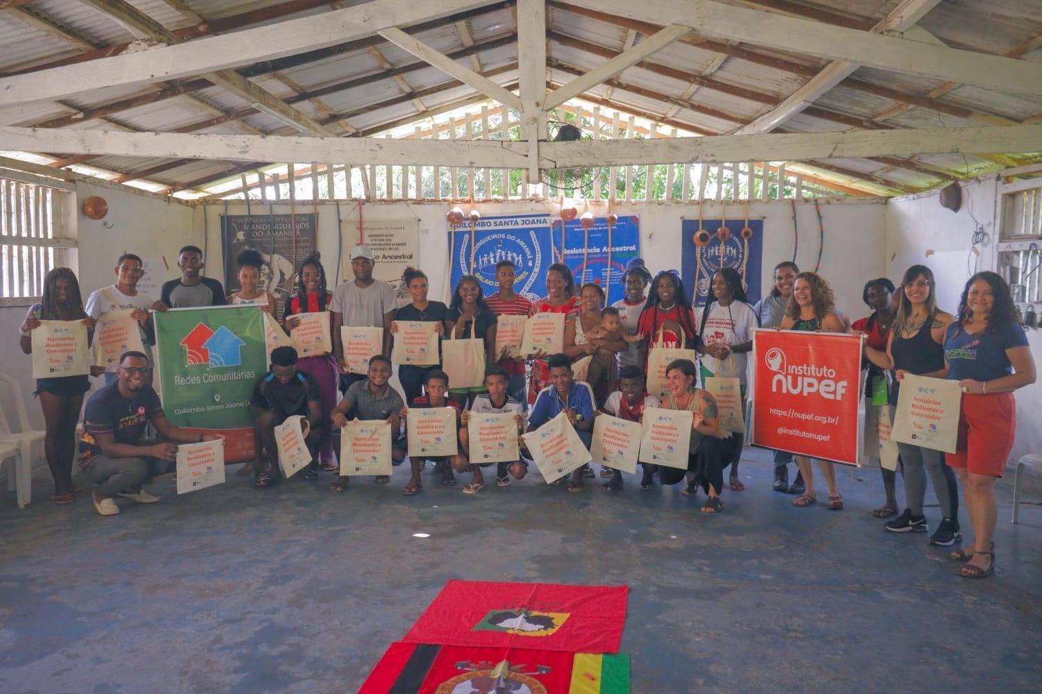 Podemos ver as pessoas participantes da oficina de pé, posando para o registro